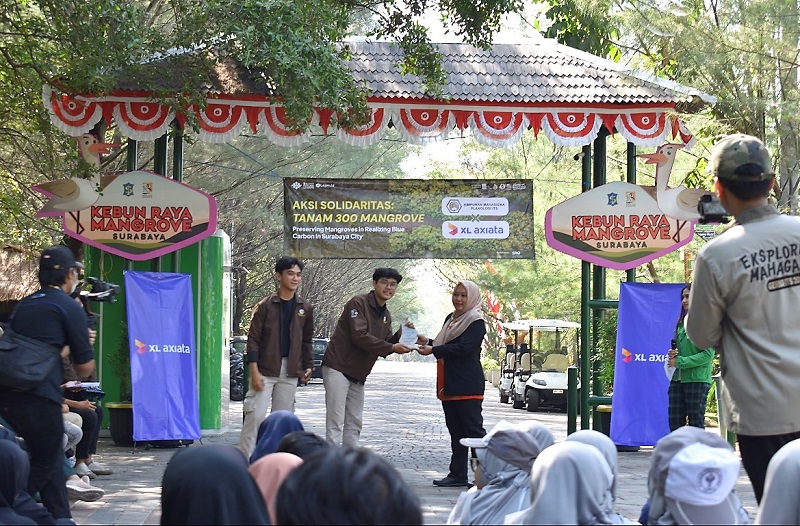 Ketua pelaksana program penanaman bibit mangrove dari Himpunan Mahasiswa Planologi ITS Surabaya, Daksa Lintang Satyawadi (Tengah) menyerahkan piagam kepada Kepala UPTD Kebun Raya Mangrove, Eva Kumalasari (kanan) di Surabaya, (25/08) yang lalu. XL Axiata melalui XL Future Leaders (XLFL) memberikan dukungan atas aksi perduli lingkungan yang juga diikuti oleh pelajar, dosen, guru, dan warga sekitar.