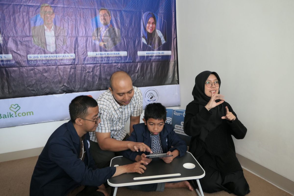 Juru Bahasa Isyarat (kanan), sedang menjurubahasakan kegiatan yang sedang berlangsung kepada dua orang santri disabilitas tuli dari Rumah Qur’an Isyaroh (kiri - tengah), di Bandung, Sabtu (20/7). XL Axiata berkomitmen dalam mendorong peningkatan kompetensi digital para penyandang disabilitas di berbagai daerah.