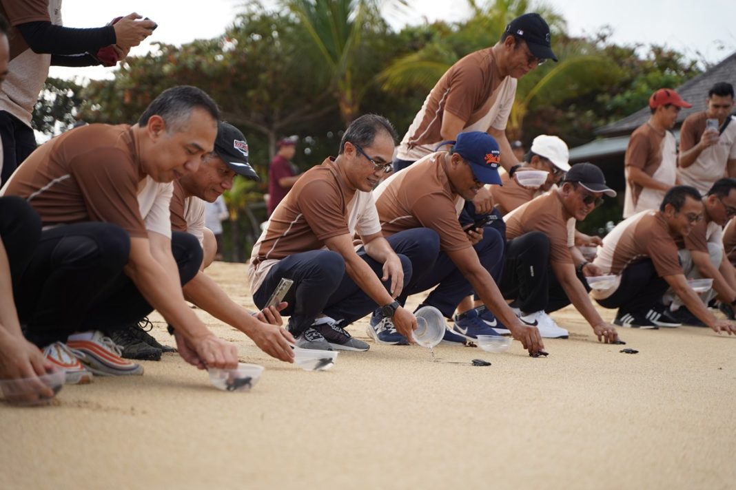 Direktur Group Business Development Telkom Indonesia, Honesti Basyir (ketiga dari kiri) dan Direktur Utama Finnet, Rakhmad Tunggal Afifuddin (ketiga dari kanan, topi hitam) saat melakukan pelepasan tukik di pantai Nusa Dua, Bali beberapa waktu lalu.