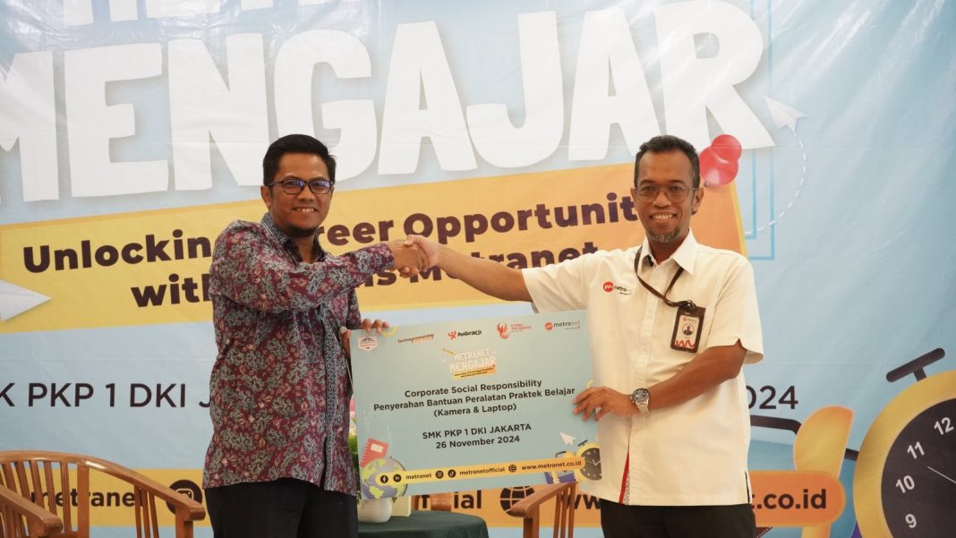 VP HCCA Legal & RM Metranet Rikki P. Ananto (Kanan) menyerahkan bantuan peralatan praktek belajar berupa satu unit laptop dan sebuah kamera set kepada Kepala Sekolah SMK PKP 1 Jakarta Yosep Saifulloh pada acara peluncuran program Corporate Social Responsibility (CSR) MetraNet Mengajar di SMK PKP 1 Jakarta, pada Selasa (26/11).