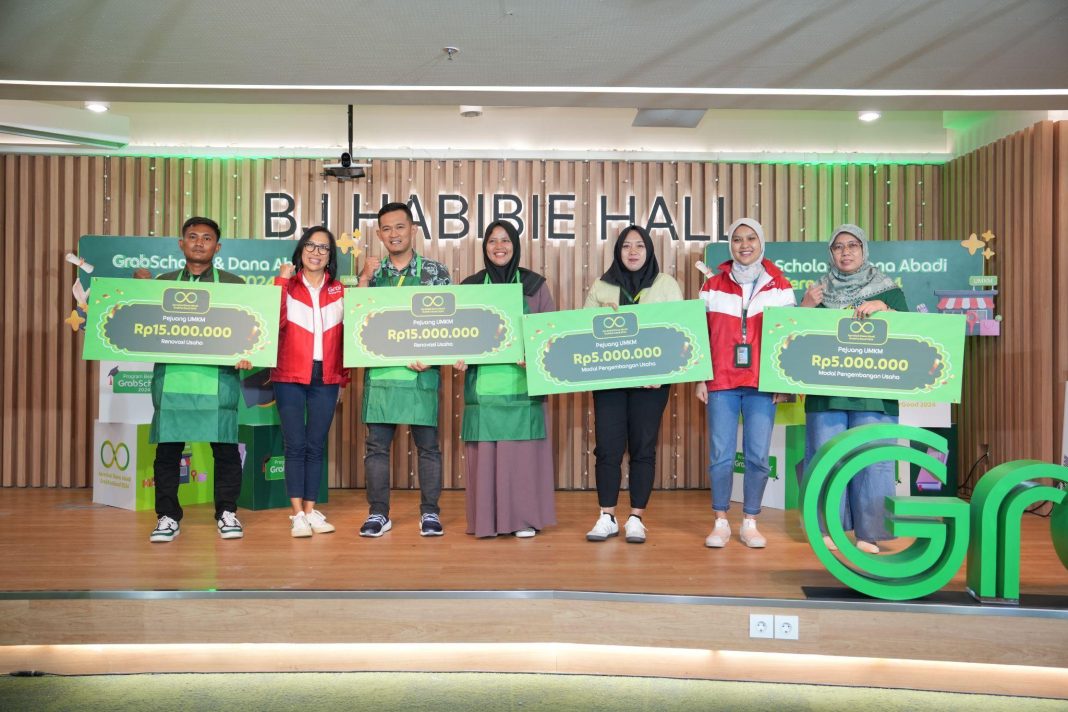 Neneng Goenadi, Country Managing Director, Grab Indonesia (kedua dari kiri) dan Rivana Mezaya, Director of Digital and Sustainability, Grab Indonesia (kedua dari kanan) menyerahkan secara simbolis bantuan modal pengembangan usaha dan renovasi usaha dari program Apresiasi Dana Abadi kepada para penerima dalam acara seremonial GrabScholar & Dana Abadi, Jakarta, Selasa (17/12).
