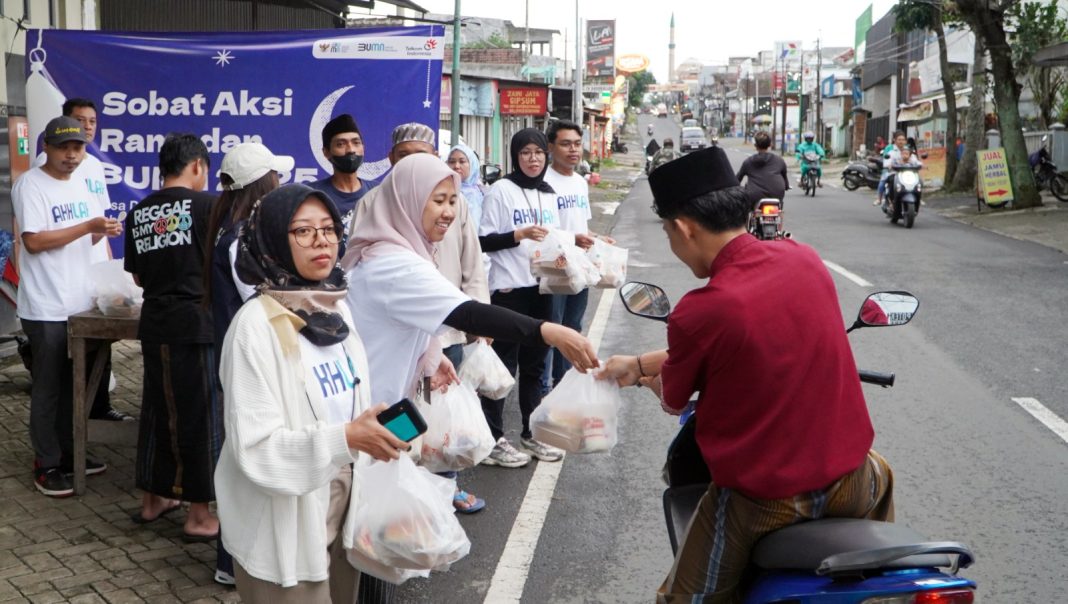 Relawan Sobat Aksi Ramadan BUMN 2025 saat melaksanakan pembagian bantuan sembako kepada warga sekitar pada acara Sobat Aksi Ramadan BUMN 2025 di Desa Karangploso Malang, Selasa (18/3).