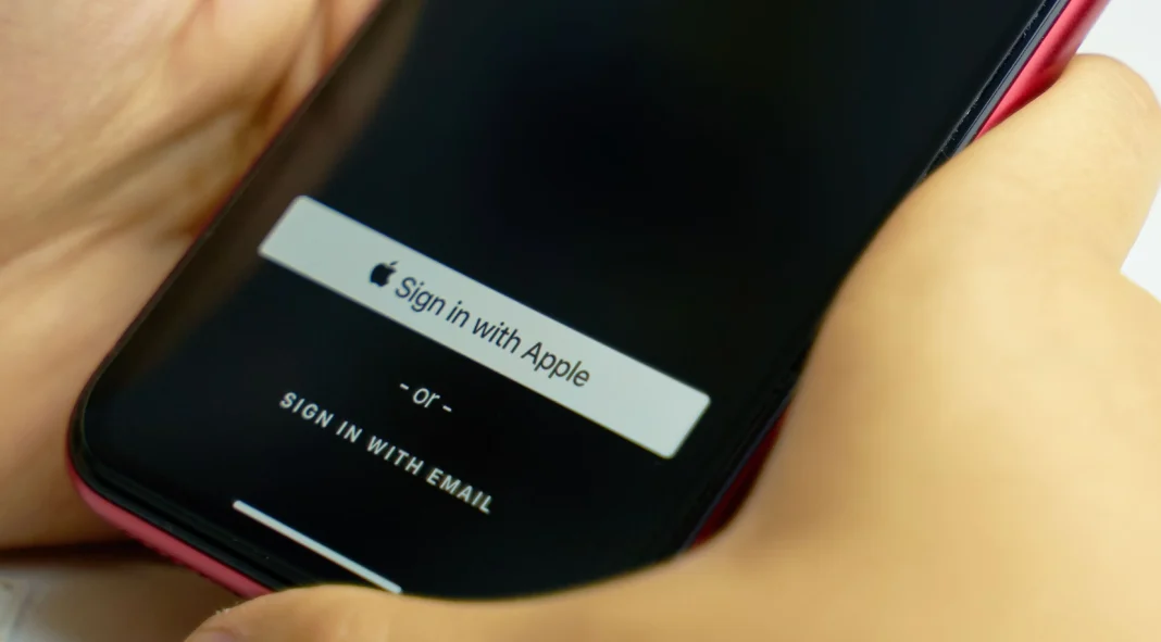 Sign in with Apple Button untuk privasi. Pria memegang smartphone dan mengotorisasi layanan internet.