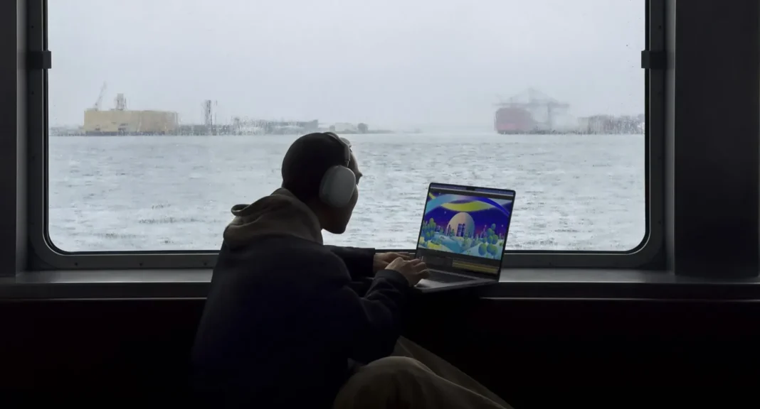 Orang bekerja menggunakan MacBook Pro M3 di atas kapal feri