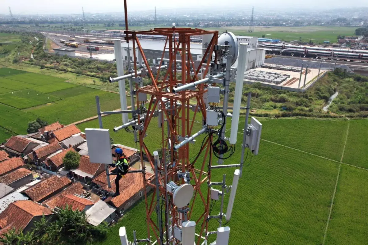 Pekerja memperbaiki pemancar sinyal internet