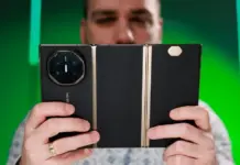 Seorang pria memegang ponsel Huawei Mate XT, ponsel lipat tiga layar pertama di dunia.