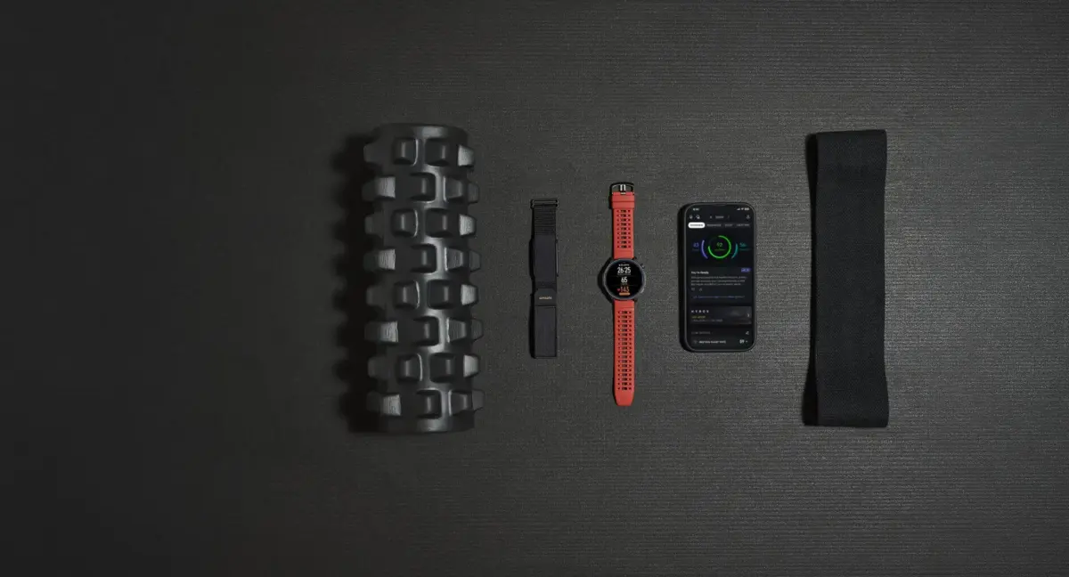 The Amazfit Balance 2 and Helio Strap devices beside a smartphone on a gym mat.