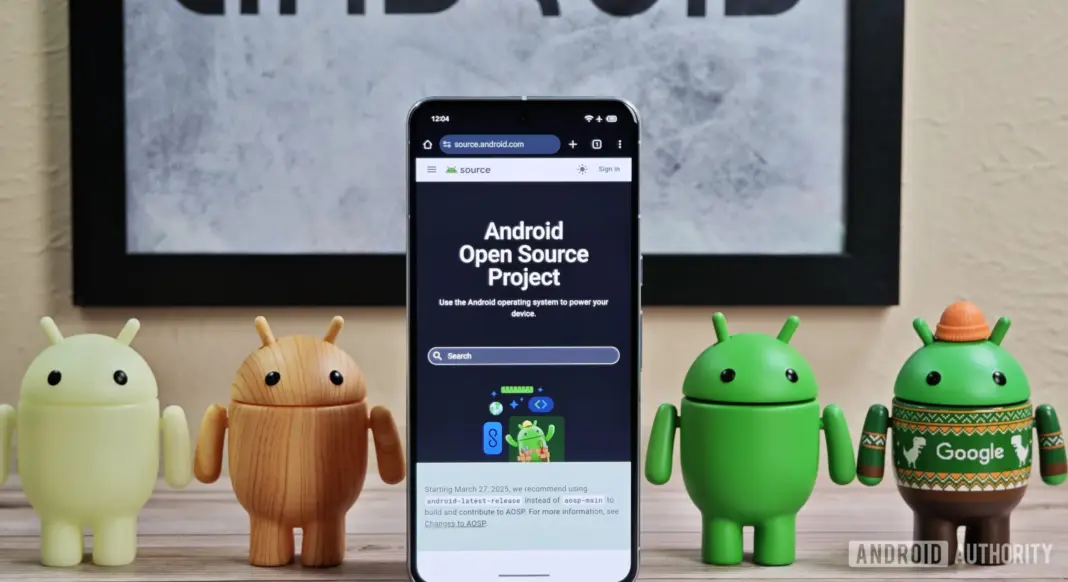 Figur Android berdiri mengelilingi ponsel Pixel dengan tampilan beranda AOSP