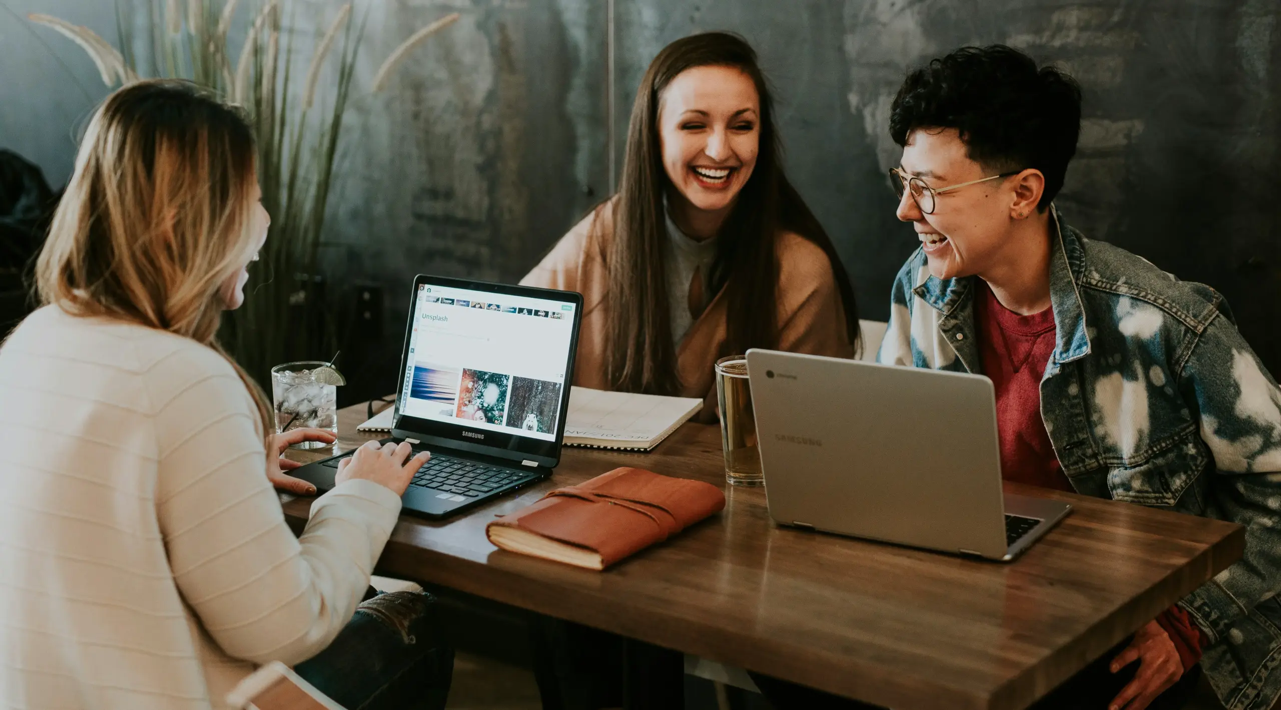 A group of young professionals sitting together with their laptops on the table