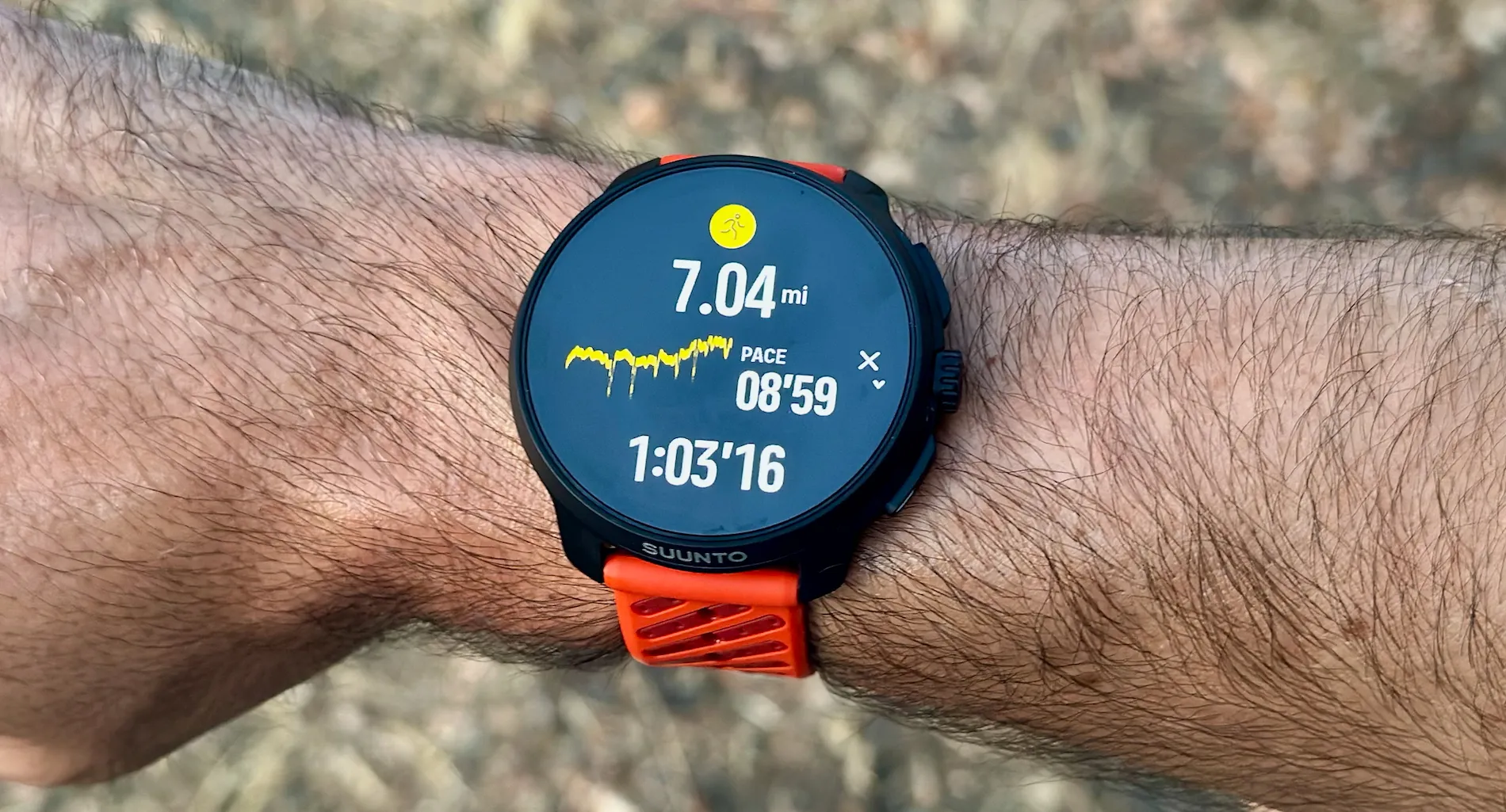 The Suunto Race 2 on the author's wrist showing a post-run summary with mileage, pace, and duration.