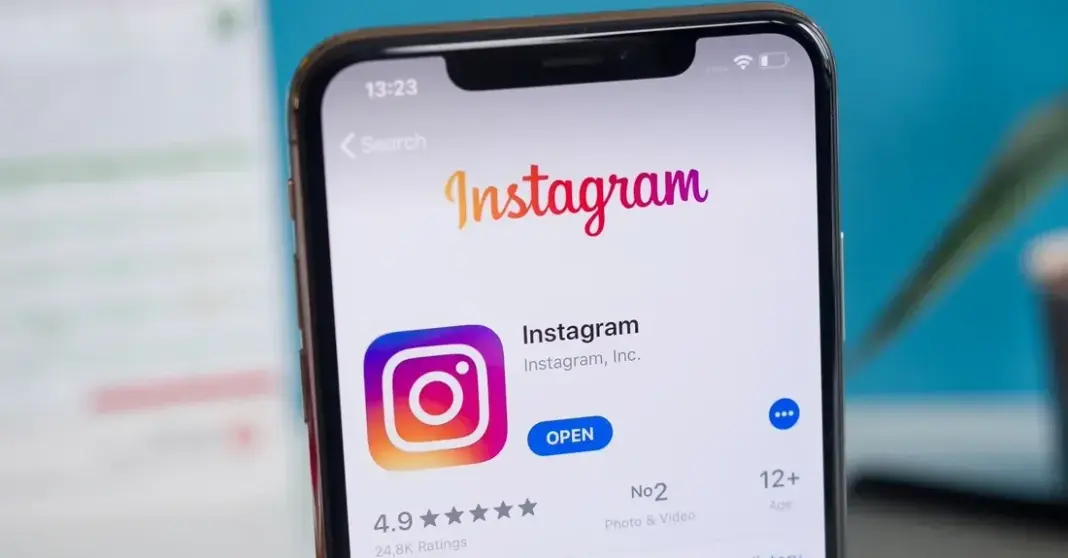 Aplikasi Instagram terbuka di layar ponsel pintar, menunjukkan antarmuka berwarna-warni dengan foto dan video