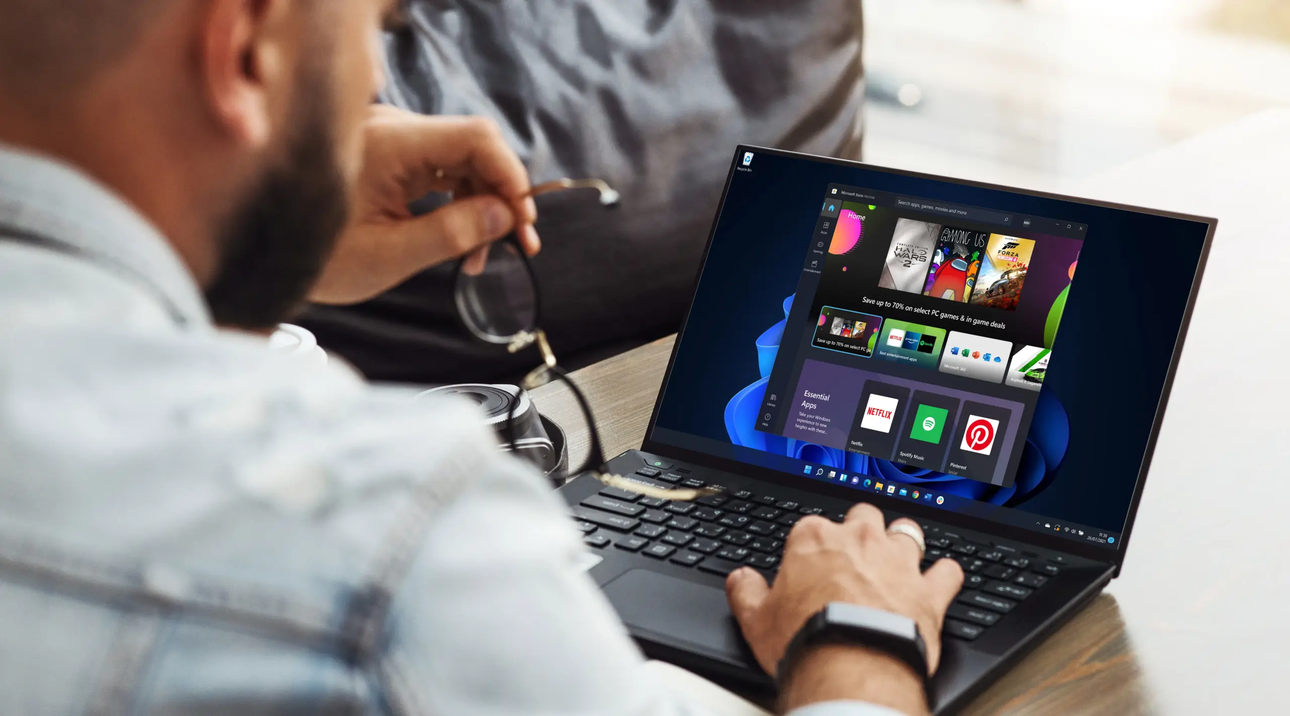 Back view of a man using a laptop with Windows 11's Microsoft Store app open