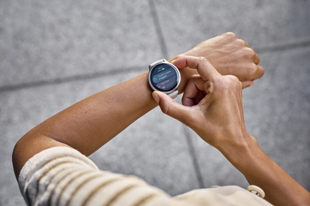 Garmin Venu 4 smartwatch dengan desain metalik elegan ditampilkan di pergelangan tangan, menampilkan tampilan kesehatan yang personal