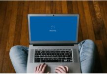 Ilustrasi laptop yang sedang restart dengan latar belakang diagram troubleshooting hardware dan software