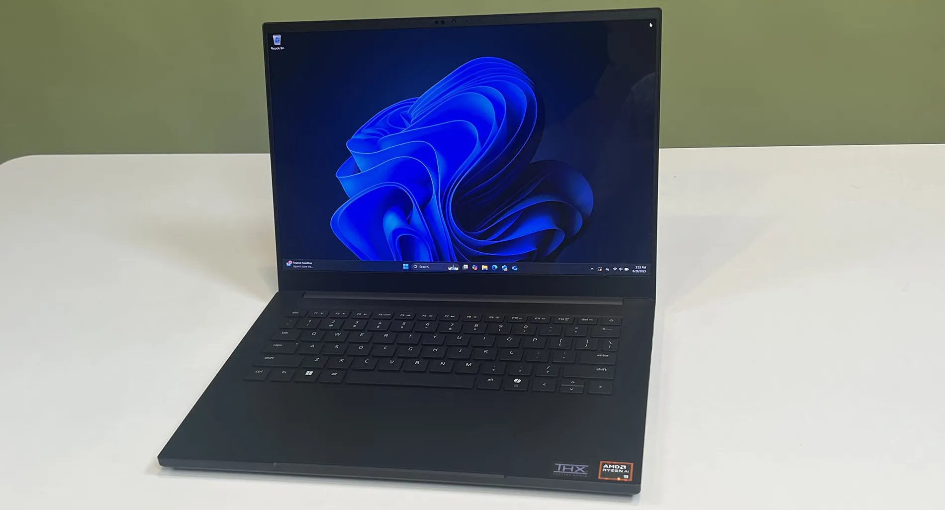 A Razer Blade 14 (2025) on a desk showing the Windows 11 desktop