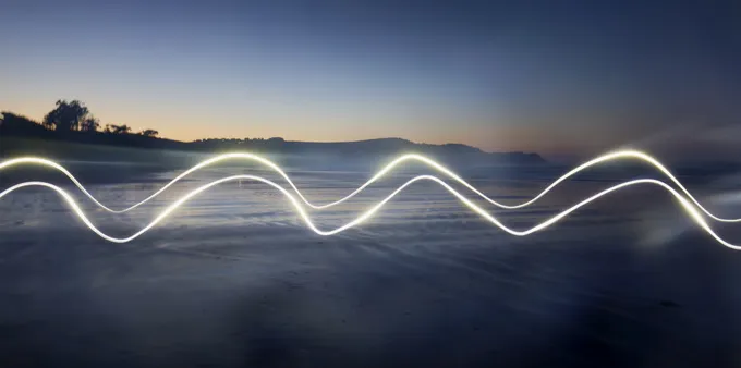 Waves travelling across a scenic background