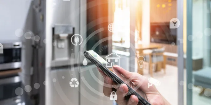 Smartphone in a kitchen with refrigerator and microwave in background