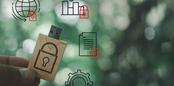 fingers holding a USB drive with lock sign