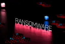 Tulisan RANSOMWARE neon dengan latar belakang gelap dan sirkuit berwarna merah biru