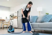 Ilustrasi vacuum cleaner modern sedang menyedot debu di lantai rumah