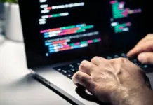 Hacker dengan kode malware di layar komputer menunjukkan serangan siber dan keamanan cyber