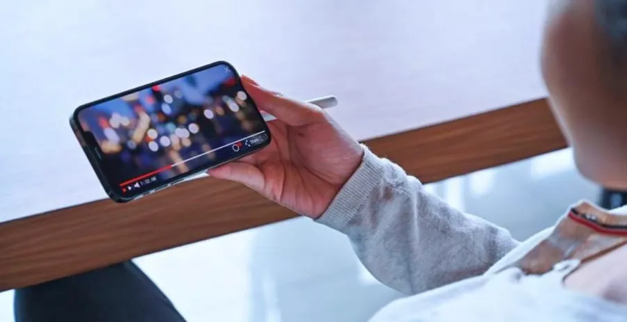 Orang menonton siaran TV melalui smartphone di berbagai situasi
