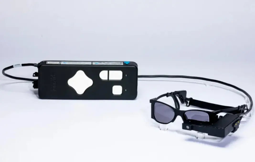 Kacamata pintar dengan kamera mini untuk membantu pasien lansia penderita AMD melihat kembali melalui teknologi implan retina dan transmisi inframerah