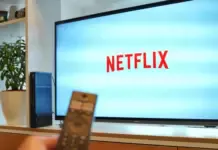 Dampak Kesepakatan Prabowo-Trump: Google Hingga Netflix Bebas Pajak di Indonesia Layar Netflix pada smart TV dengan remote di depannya, ilustrasi penggunaan smart TV modern