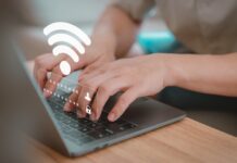 Ilustrasi pengguna sedang mengakses pengaturan router IndiHome di laptop untuk mengganti password WiFi