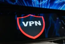 VPN berjalan di ponsel yang diletakkan di atas keyboard laptop, ilustrasi privasi digital