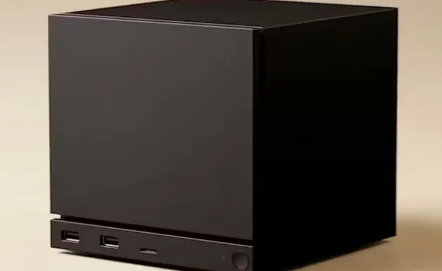 A black, cubical unbranded device with two USB ports and a power button on a beige background.