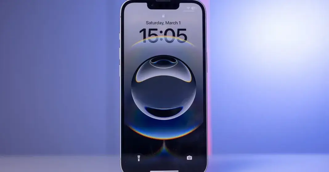 iPhone diletakkan di atas meja dengan latar belakang minimalis, merepresentasikan desain kompak iPhone 17e