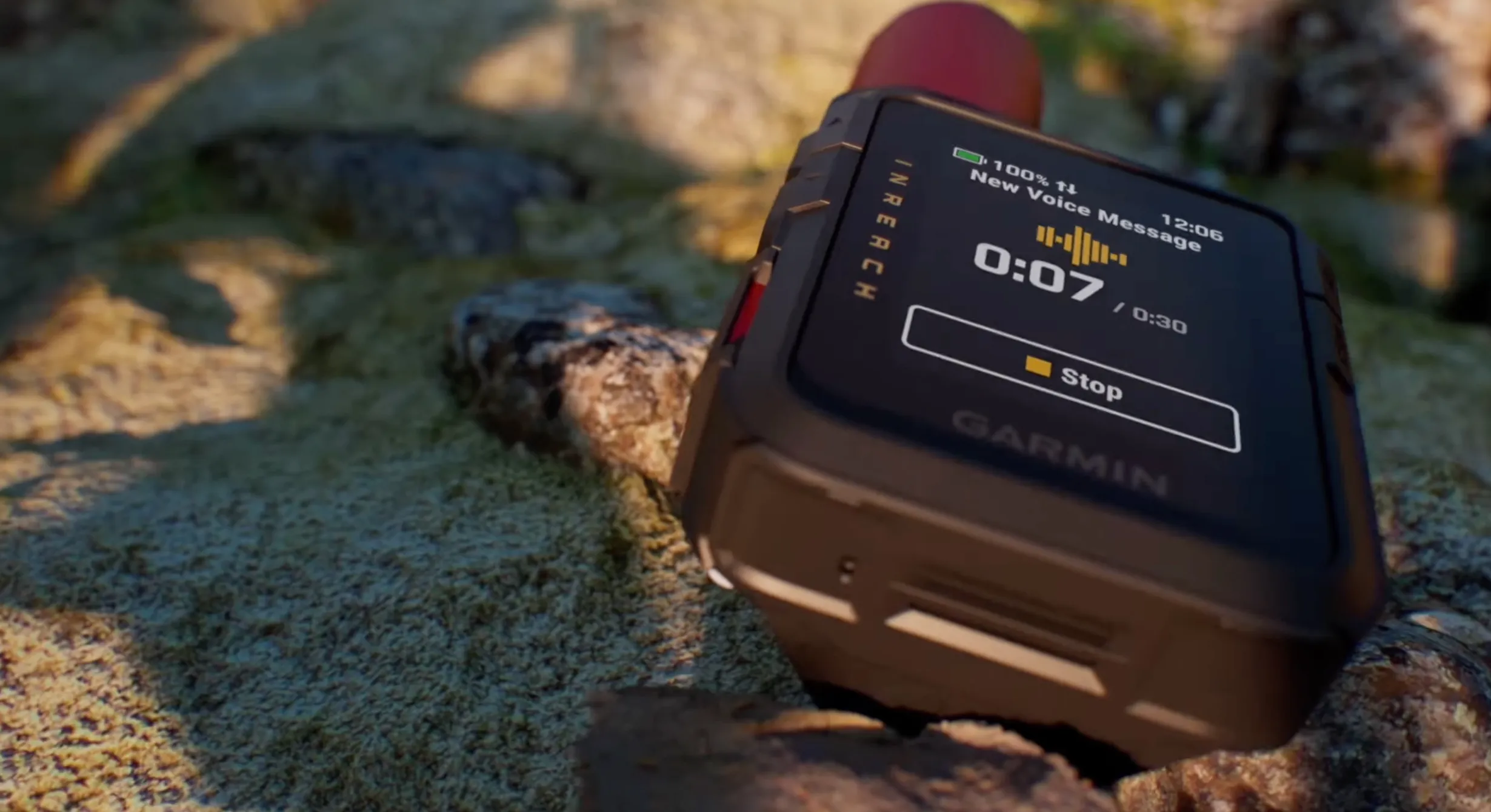 The Garmin InReach Mini 3 sitting on a rock, showing a new voice message.