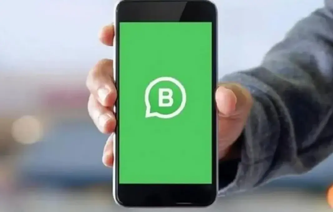 Ilustrasi aplikasi WhatsApp Business (WhatsApp Bisnis) di smartphone dengan ikon percakapan dan bisnis.