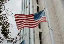 AS Usulkan Syarat Baru: Histori Medsos 5 Tahun untuk Masuk Tanpa Visa Ilustrasi pemeriksaan paspor dan perangkat digital di bandara, mewakili aturan baru screening media sosial untuk masuk Amerika Serikat.