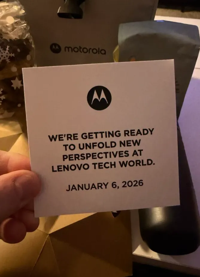 Paket hadiah liburan Motorola yang berisi petunjuk peluncuran ponsel lipat buku, menampilkan notepad kayu dengan tulisan Every fold reveals a possibility