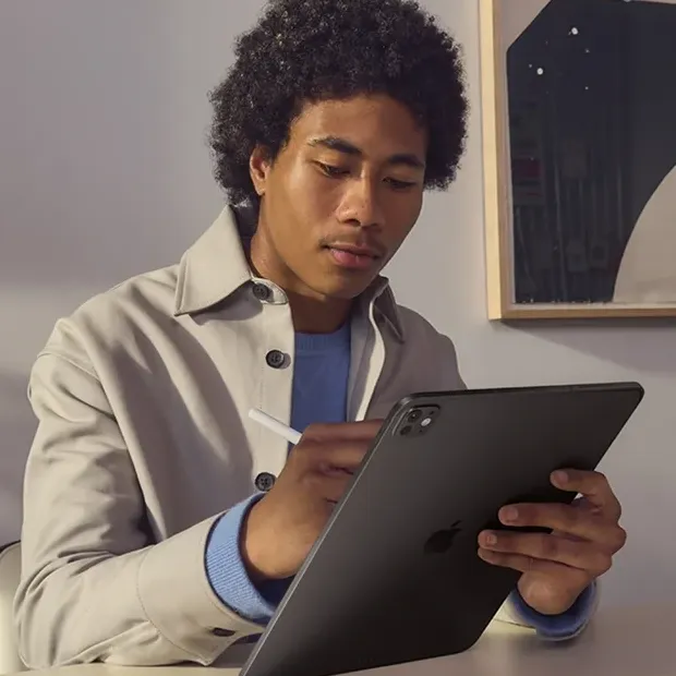 iPad Pro M5 dengan desain tipis diletakkan di atas meja kayu