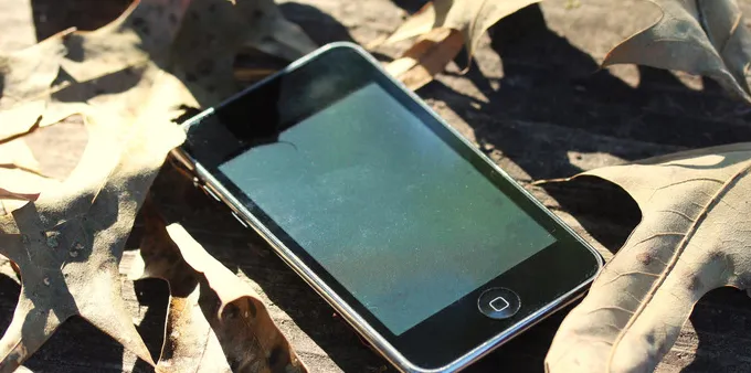 An iPod touch on a wooden table.