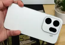 Close-up smartphone flagship premium dengan desain metalik dan kamera besar, diletakkan di atas permukaan kayu.