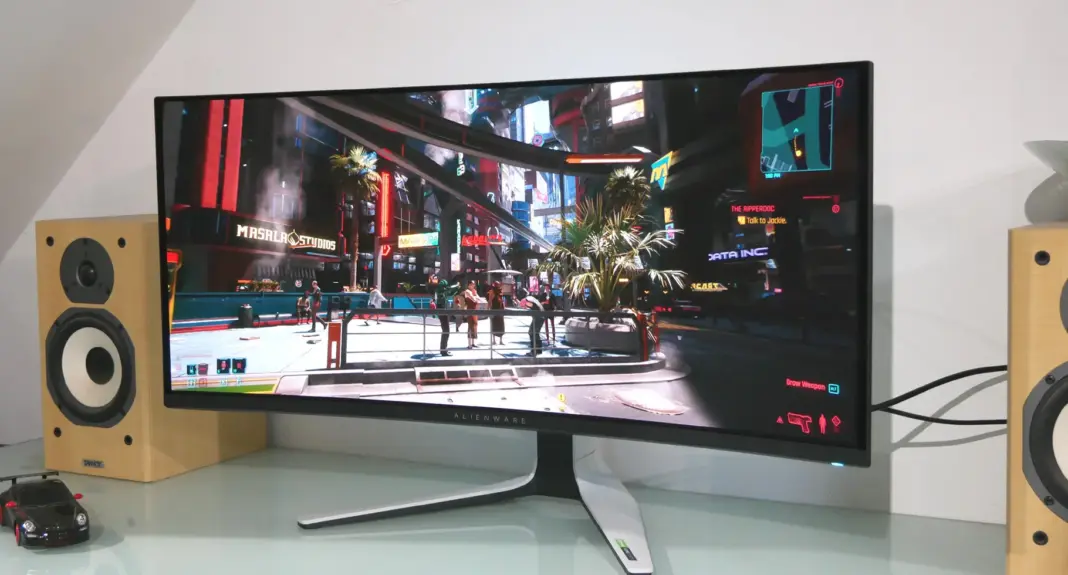 Monitor gaming OLED ultrawide Alienware AW3423DW di atas meja kerja setup gaming modern