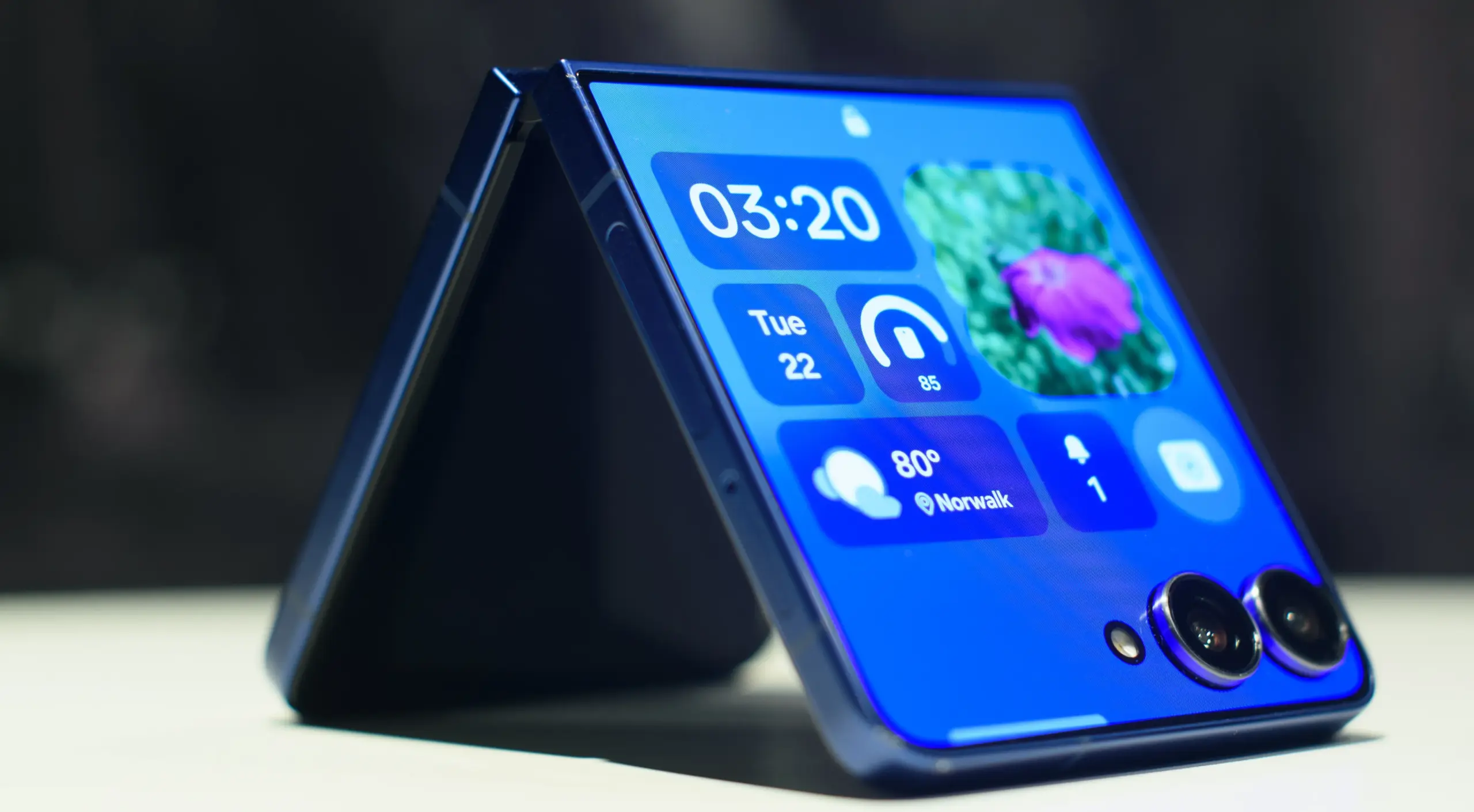 Samsung Galaxy Z Flip 7 in blue folded showing widgets on the cover display