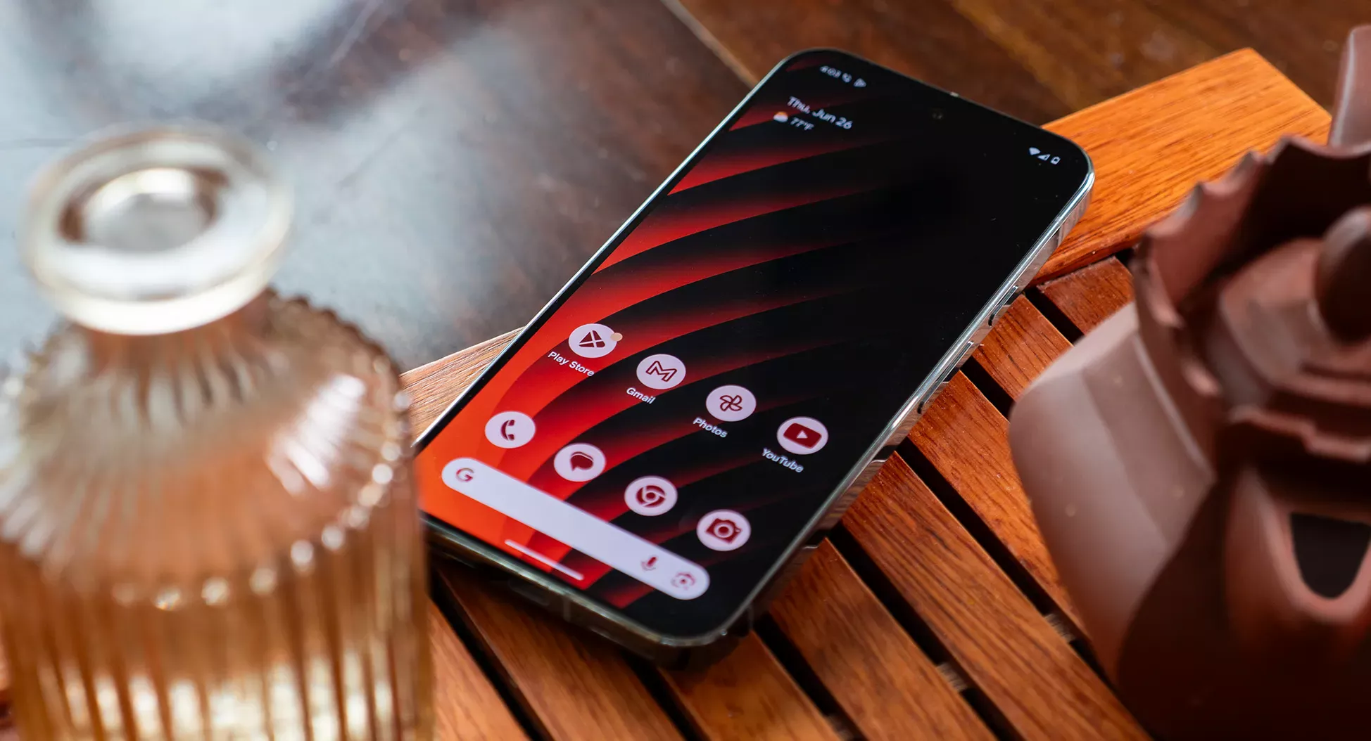 A Google Pixel 9 Pro XL with an orange and red striped wallpaper on a tea tray