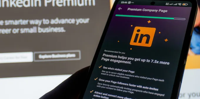 Person holding a phone showing LinkedIn Premium features page
