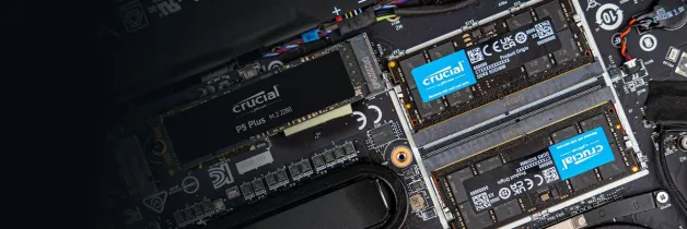 Sebuah laptop terbuka memperlihatkan SSD Crucial P5 Plus M.2 2280 dan dua modul memori DDR5 SODIMM Crucial yang terpasang di motherboard.