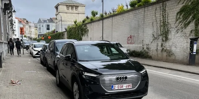 A black Audi Q4 E-Tron parked along a brick sidewalk.