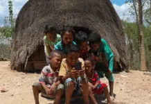 Ilustrasi anak kecil memegang smartphone dengan ekspresi serius, menggambarkan bahaya gadget dini menurut penelitian terbaru.